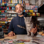 gato com dono de mercearia